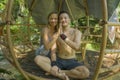 Outdoors portrait of young beautiful and happy couple practicing yoga workout together at tropical forest gazebo smiling cheerful Royalty Free Stock Photo