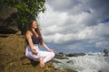 Outdoors portrait of young beautiful and happy red hair woman practicing yoga and meditation exercise in lotus position at beach Royalty Free Stock Photo