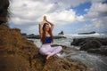 Outdoors portrait of young beautiful and happy red hair woman practicing yoga and meditation exercise in lotus position at beach Royalty Free Stock Photo