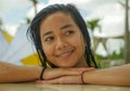 Outdoors portrait of young beautiful and sweet Asian Indonesian teenager girl swimming at tropical resort pool smiling happy and Royalty Free Stock Photo