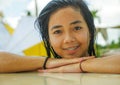 Outdoors portrait of young beautiful and sweet Asian Indonesian teenager girl swimming at tropical resort pool smiling happy and Royalty Free Stock Photo