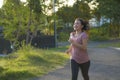 Outdoors running workout - young happy and dedicated Asian korean woman jogging at beautiful city park or countryside trail on Royalty Free Stock Photo