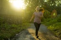 Outdoors running workout - young happy and dedicated Asian Korean woman jogging at beautiful city park or countryside trail on Royalty Free Stock Photo
