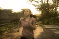 Outdoors running - young happy and dedicated Asian Japanese woman jogging workout at beautiful city park or countryside trail on Royalty Free Stock Photo