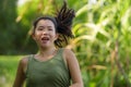 Outdoors running - young happy and dedicated Asian Japanese woman jogging workout at beautiful city park or countryside trail on Royalty Free Stock Photo