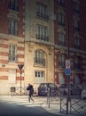 Outdoors scene with a person crossing the street on the crosswalk in Asnieres sur Seine, a Paris suburb, France Royalty Free Stock Photo