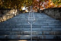 Outdoors stairs in perspective with chrome handrail leading up to fall colored trees. Royalty Free Stock Photo