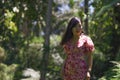 Outdoors Summer lifestyle portrait of young beautiful and happy Asian Chinese woman in elegant dress walking tranquil and cheerful