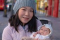 Outdoors urban lifestyle portrait of young happy and beautiful Asian Korean woman as mother of little adorable baby girl holding Royalty Free Stock Photo