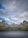 Outdoors view to the Louvre Museum in Paris, France. The historical palace building with the modern glass pyramid in center,