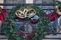 Outdoors Winter Holiday decoration concept: Christmas Wreath with Golden Jingle Bells and Holly Berries decorating Royalty Free Stock Photo