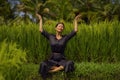 Outdoors yoga and meditation at rice field - attractive and happy middle aged Asian Korean woman enjoying yoga and relaxation in