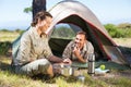 Outdoorsy couple cooking on camping stove outside tent Royalty Free Stock Photo