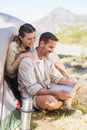 Outdoorsy couple looking at the laptop outside tent