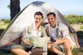 Outdoorsy couple looking at the map outside tent