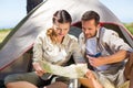 Outdoorsy couple looking at the map outside tent Royalty Free Stock Photo