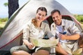 Outdoorsy couple looking at the map outside tent