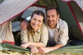 Outdoorsy couple smiling at camera from inside their tent Royalty Free Stock Photo