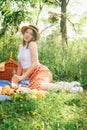 Outdoorsy young woman on blue blanket, having a picnic