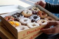 Outer Banks NC, USA 05-26-2022: A cardboard box of a dozen donuts bought from the chain store Duck Donuts. A popular selection of