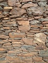 Outer wall of a house made of flat red rock