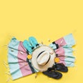 Outfit for beach tropical vacations, straw sun hat, towel, sun glasses on yellow. Summer concept. Top view Royalty Free Stock Photo