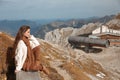 Outfit of casual woman. Brunette sitting on bench enjoying nature above mountains view landscape. Travel Lifestyle adventure