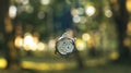Outgoing not limited time concept picture vintage clock falling down on blurred abstract colorful nature background Royalty Free Stock Photo