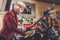 Outgoing pensioner cleaning motorcycle in garage
