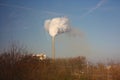 Outlet of a chimney that dumps the remains of industrial processing into the clear blue sky, polluting our beautiful planet