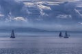 The outlines of mountains, rare silhouettes of sailboats are visible on the horizon