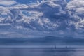 The outlines of mountains, rare silhouettes of sailboats are visible on the horizon