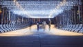 The outlines of people walking along the night alley illuminated by bright hanging garlands. Selective focus.