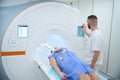Radiographer positioning adult patient for brain MRI