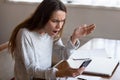 Outraged young mixed race girl looking at mobile phone screen. Royalty Free Stock Photo