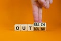Outreach or outbound symbol. Businessman turns wooden cubes and changes the word `outbound` to `outreach`. Beautiful orange ta