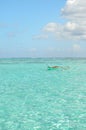 Outrigger canoe in clear lagoon water Royalty Free Stock Photo