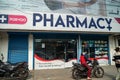 Outside, exterior view of the Porvoo Pharmacy store, as a customer on a motorbike drives by