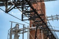 An outside industrial conveyer belt at an old tobacco factory with bright blue sky and a brick smoke tower. Royalty Free Stock Photo