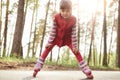 Outside picture of energetic serious little girl being in forest, having roller blades on legs, enjoying active lifestyle, having Royalty Free Stock Photo