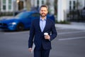 Outside portrait of man in suit. Businessman walking in city. Hispanic man walk on street. Business man with laptop and Royalty Free Stock Photo