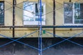 Outside repair and renovation of apartment house, blue metal scaffolding tower