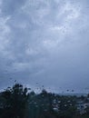 Outside, it`s raining in the city. View from the window. Rain outside the window in the evening. Royalty Free Stock Photo