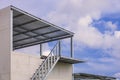 Outside steel staircase on gray smartboard wall with terrace structure of modern house against cloudy on blue sky in home