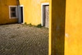 Outside view of deserted house with old and grungy yellow wall, window and worn door. Royalty Free Stock Photo