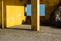 Outside view of deserted house with old and grungy yellow wall, window and worn door.