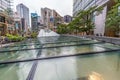 Outside view of Tokyo Midtown complex and metro station with people walking and seating around