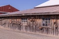 Outside wall of an old barn with old rusty obsolete agriculture instruments on it Royalty Free Stock Photo