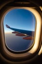 Outside the window`s airplan sunset seen with aircraft wing.