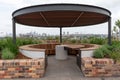 Outside wooden tables and benches on a rooftop overlooking the city Royalty Free Stock Photo